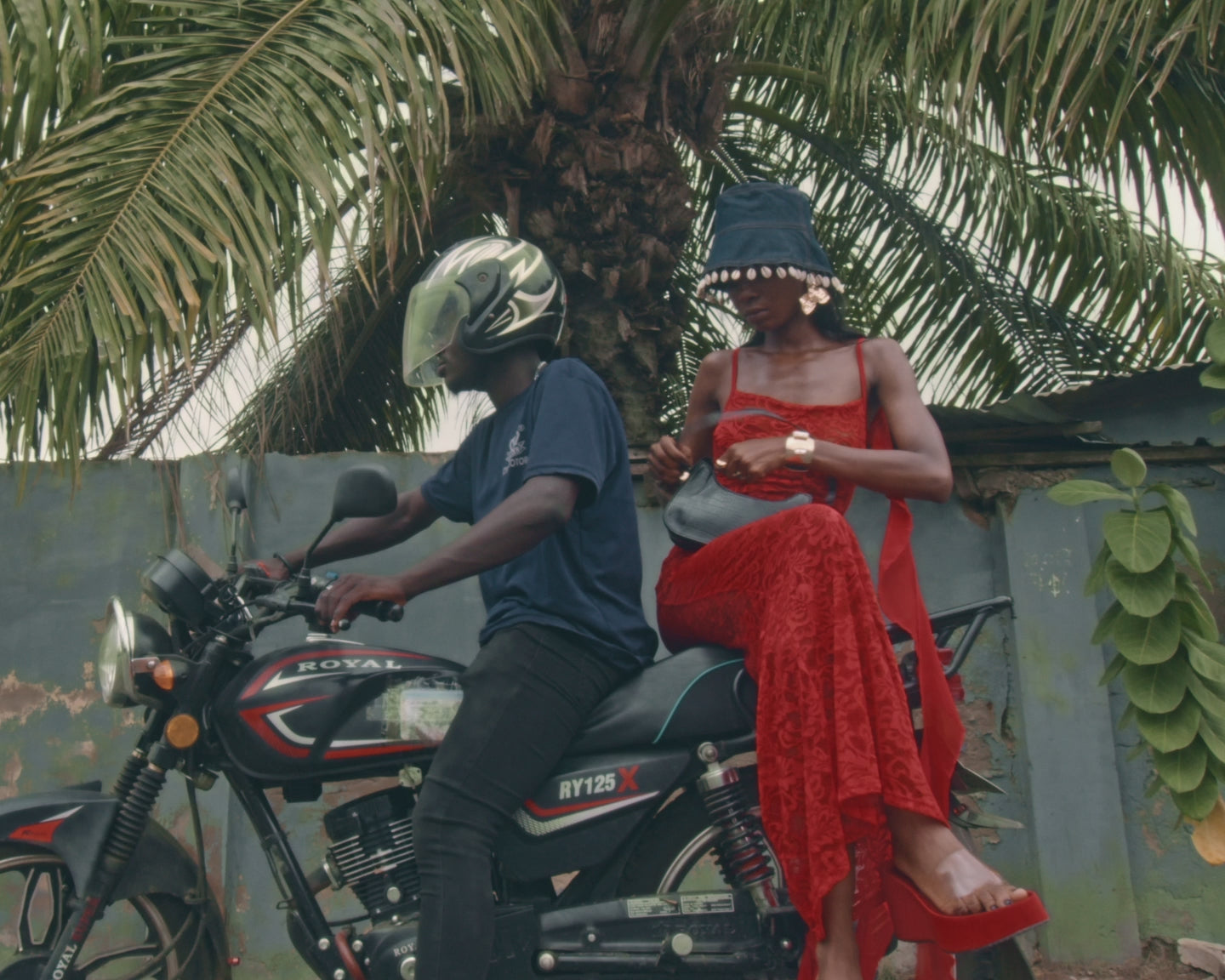 Load video: man and woman on a motorcycle. woman closes her bag before bike goes.